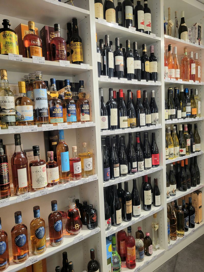 La cave, bouteilles de vins et de spiritueux sur les étagères blanches