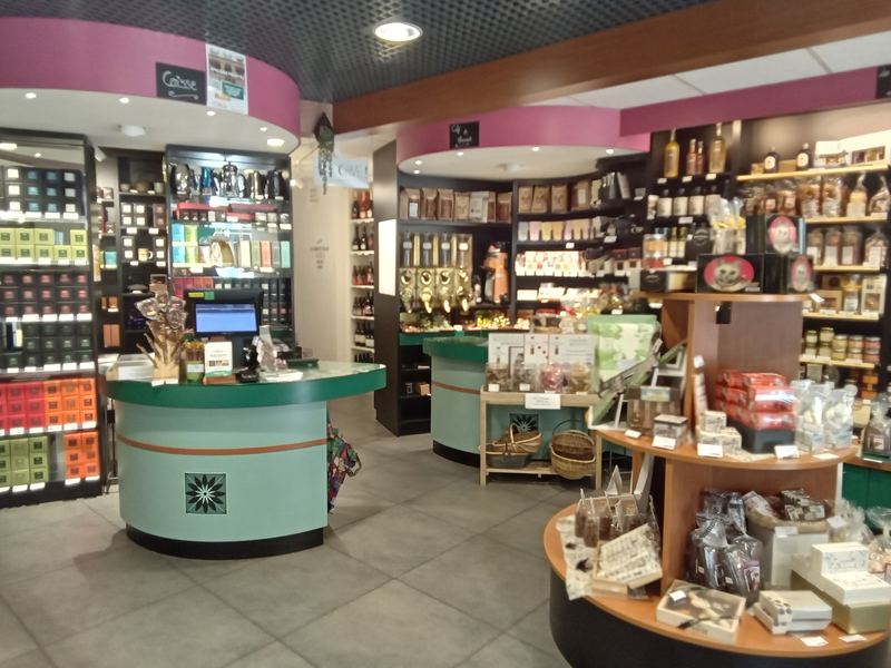 L'intérieur de la boutique, comptoirs vert d'eau et rayons d'épicerie